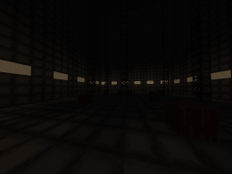 A large metal room with steel beams going to the roof. Dim lights lining the walls. Wooden crates on the floor.